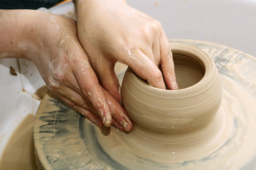 pottery. the teacher teaches the student work on the potter's wheel.