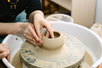 pottery. the teacher teaches the student work on the potter's wheel.