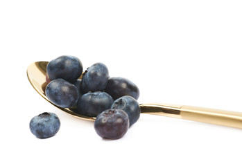 Golden spoon full of bilberries