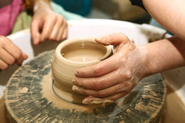 Fototapeta na wymiar pottery. the teacher teaches the student work on the potter's wheel.