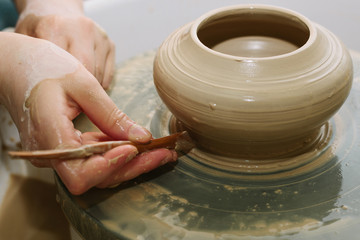 pottery. the teacher teaches the student work on the potter's wheel.