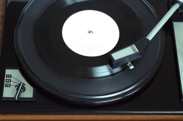 Old vintage record player playing vinyl record with pink label. Top view horizontal photo view 