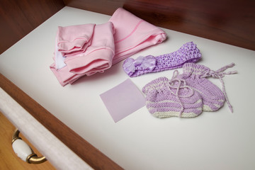 chest of drawers with baby girl, newborn clothes. Waiting for child