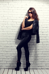 fashion model in sunglasses, black leather jacket, leather pants