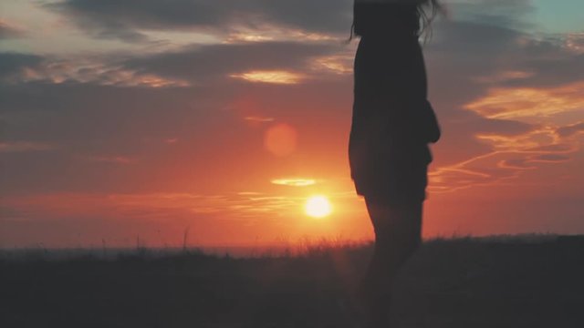 Happy girl jumping at sunset