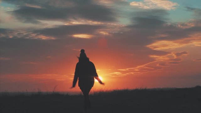 Happy girl jumping at sunset