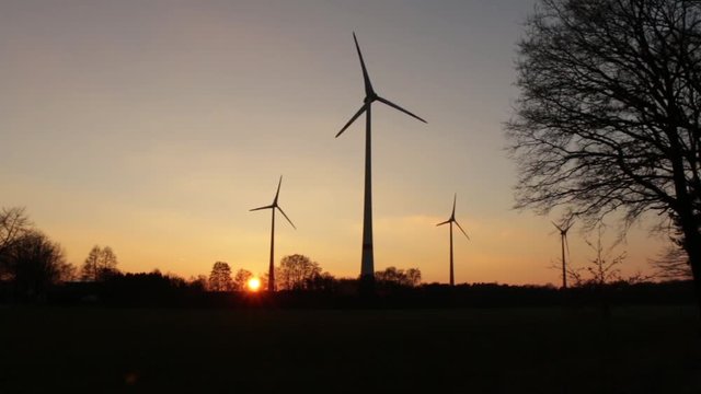 Drehende Windr&auml;der im Sonnenuntergang, im Bioenergiepark der Kilmakommune Saerbeck
