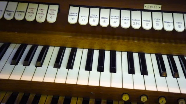 Pan along a vintage organ keyboard with two levels of keys visible.