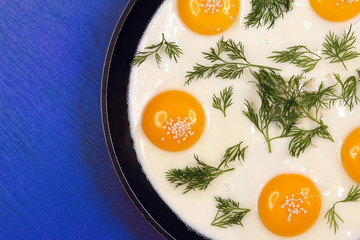  pan on the table with fried scrambled eggs with dill and sesame