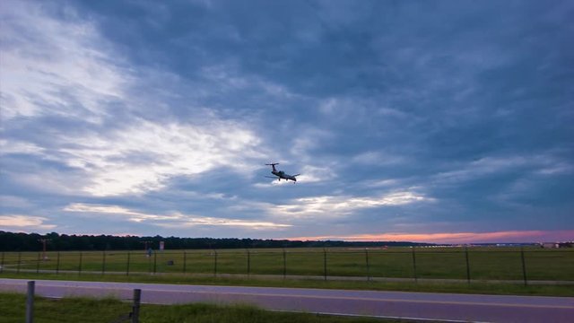 Unmarked Regional Jet Airliner on Final Approach Landing and Arriving Early Evening or Morning with Vibrant Colors in the Sky from Wide Angle