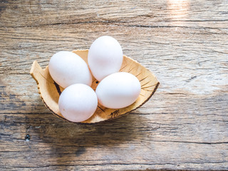 duck eggs in coconut cup on wood background