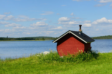 Finnish sauna on shore of blue lake, Northern Finland, Lapland