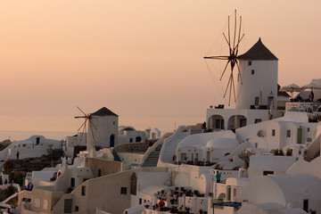 Amazing Sunset over white windmills in  town of Oia and panorama to Santorini island, Thira,...