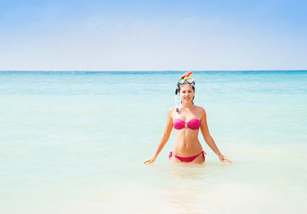 Beautiful, smiling girl in pink bikini diving in the sea