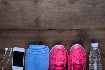 Fitness and sport equipment : Measuring tape,mat.sneakers,towel,bottle of water with wooden background on top view