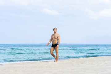 Young, fit handsome man on a summer beach
