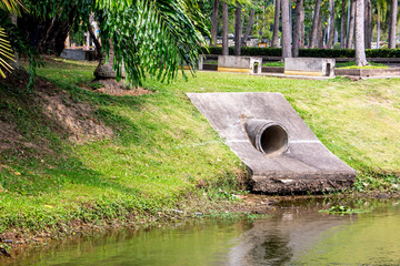 Large cement sewer drain pipe into the lake in the park