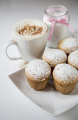 Freshly baked homemade muffins with powdered sugar and coffee