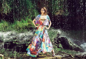 Obraz na płótnie Canvas Beautiful fashion model posing in front of a waterfall