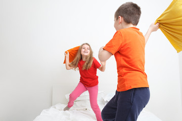 kids having a pillow fight in bed