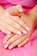 Female hand with manicure on a pink background