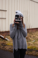 Teenage girl talking photos with a polaroid camera 