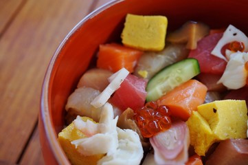 Bowl of chirashi sushi with mixed raw fish and salmon roe over rice