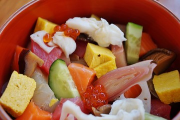 Bowl of chirashi sushi with mixed raw fish and salmon roe over rice