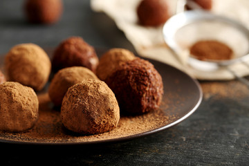 Sweet chocolate truffle on a black wooden table