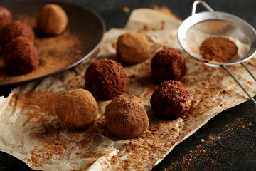 Sweet chocolate truffle on a black wooden table