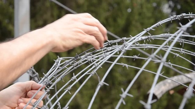 Fl&uuml;chtlinge am Stacheldrahtzaun