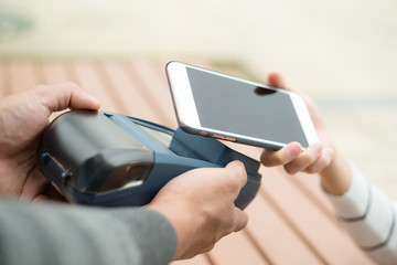 Woman pay on cellphone with NFC technology