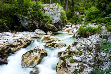 Fototapeta premium Strömender Bachlauf mit Felsen und Geröll