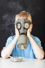 Child in gas mask near cigarettes