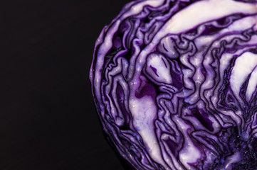 Purple cabbage cut in half dark background, close up space for text