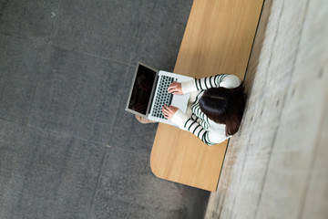 Top view of woman using notebook computer