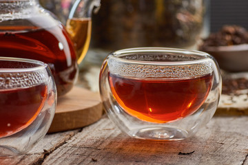 Black tea in the glass teapot and cups