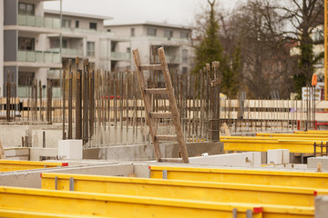 Eine Leiter aus Holz guckt zwischen Holzträgern aus einem Rohbau