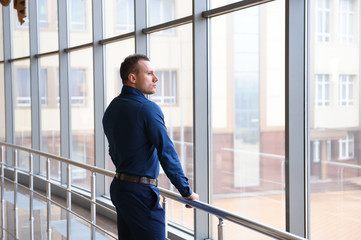 businessman looking through the phone by the window