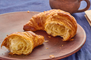 Broken croissant and a cup of coffee