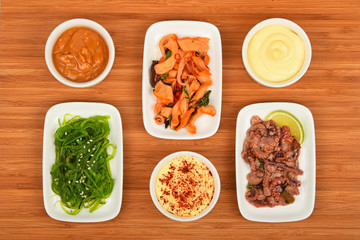 Three seafood salads with sauce on wood