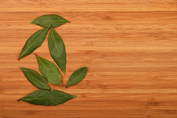 Bay laurel leaves on bamboo wooden board