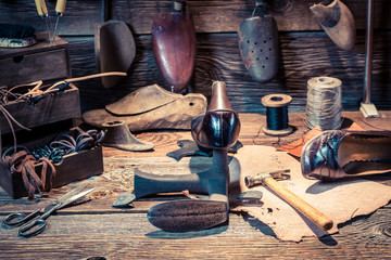 Cobbler workplace with tools, shoes and laces