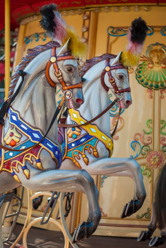 Bright carousel in a holiday park. Horses on a traditional fairground vintage carousel. Merry-go-round with horses. (Real Photo)