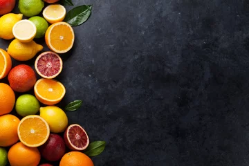 Foto op Plexiglas Verse citrusvruchten op donkere steen © karandaev