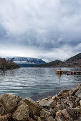 Small fishing boats by small wooden pier in a fjord in Norway