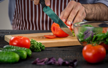 Obraz na płótnie Canvas Male hands cutting vegetables for salad