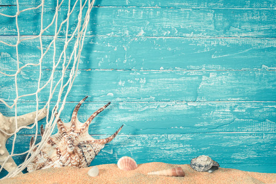 Fishing net and sea shells on sand on blue