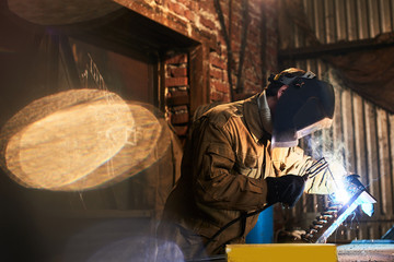 Obraz na płótnie Canvas The welder produces welding parts