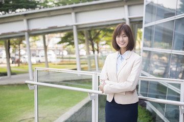 Attractive asian business woman smiling outside office